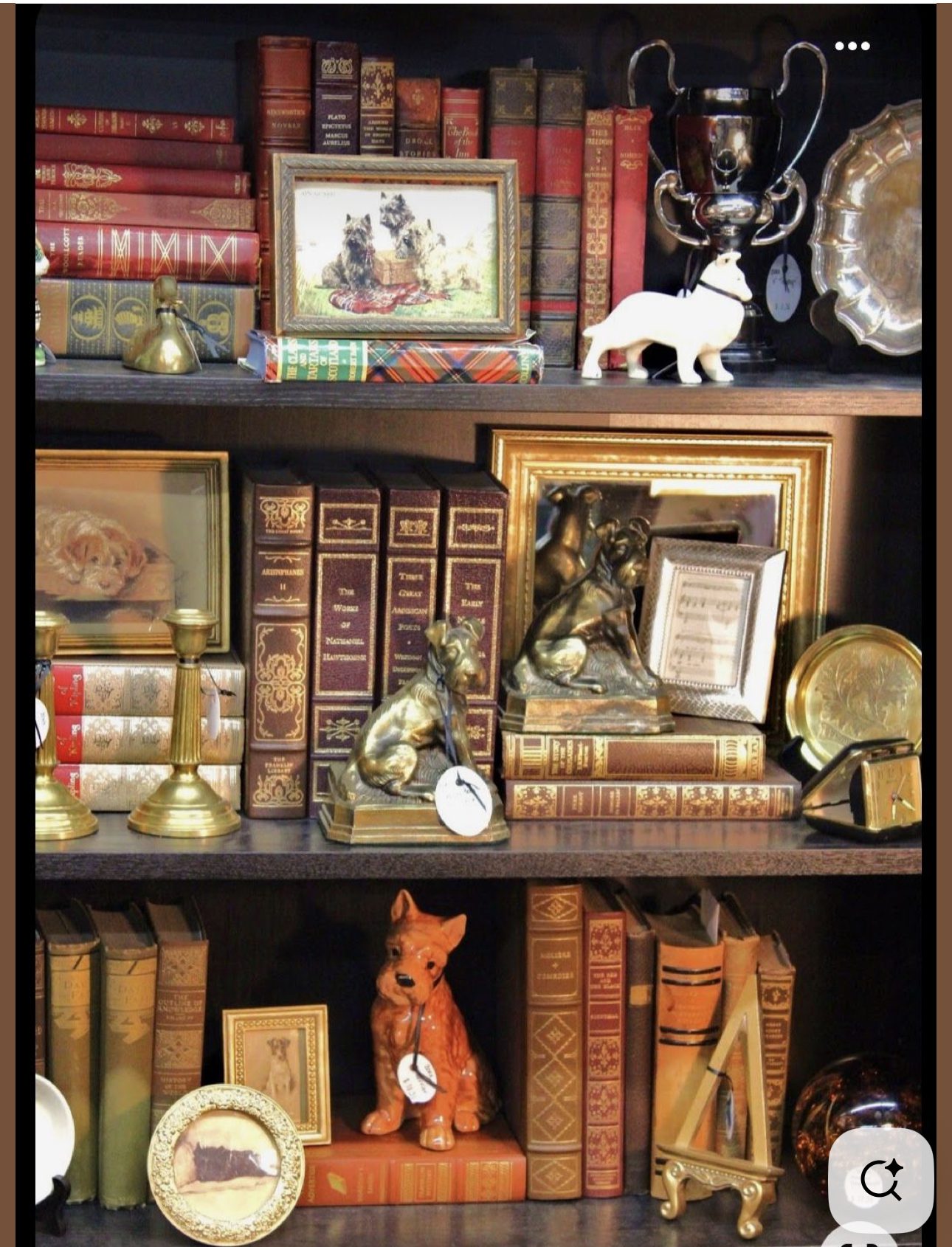 Vintage bookshelf with antique books, decorative items, and animal figurines.