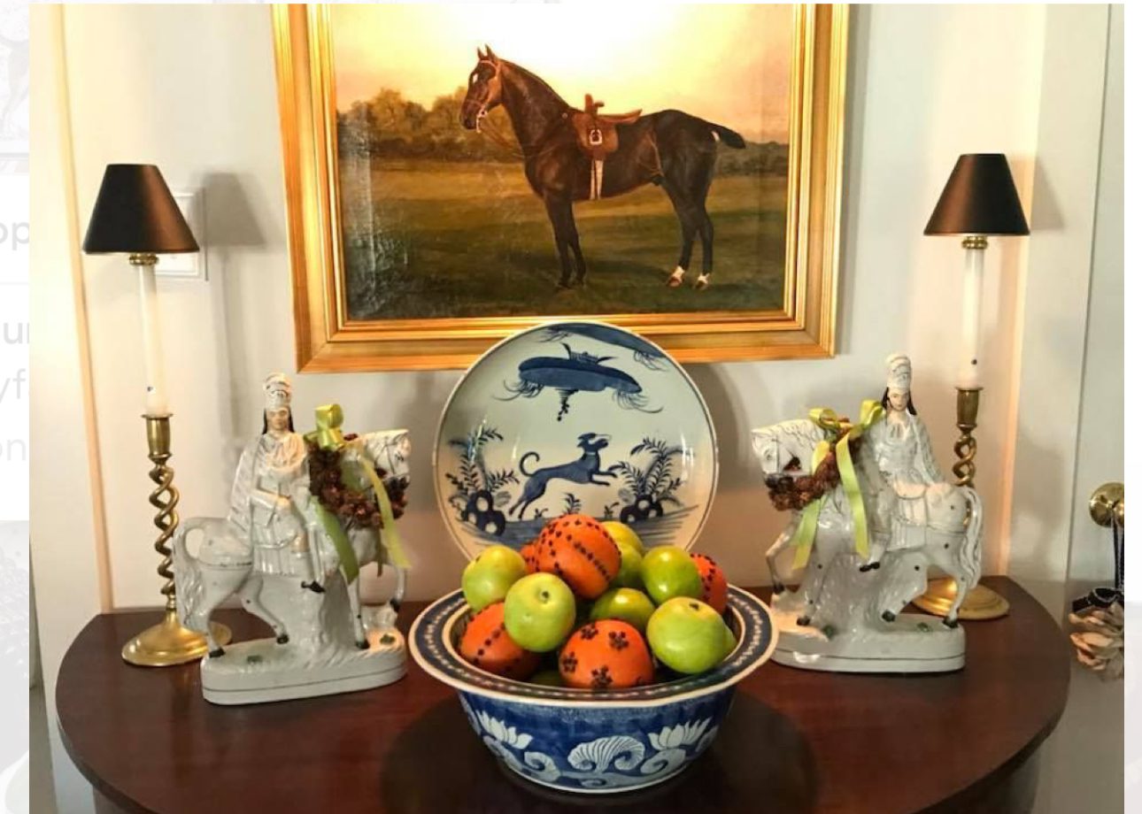 Elegant still life with fruit bowl and horse painting.