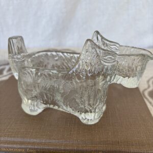 Clear glass dog-shaped container with intricate detailing.