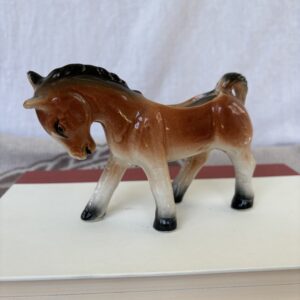 A small ceramic horse figurine with a glossy finish.