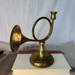 Antique brass candle holder shaped like a horn.