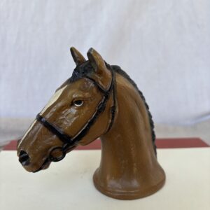 A detailed horse head sculpture with braided mane and bridle.
