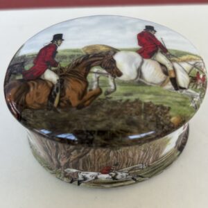 Oval box with a detailed hunting scene on its lid.