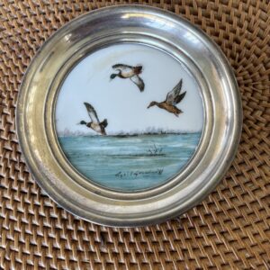 Decorative plate featuring flying birds over the sea.