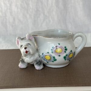 Ceramic dog planter with floral design and a white dog figure.